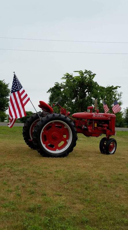 red tractor with american flags attached